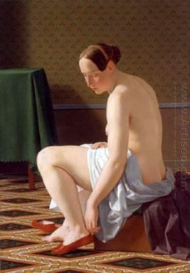 Mujer desnuda que pone en sus zapatillas