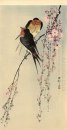Two barn swallows on blossoming cherry