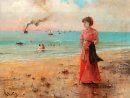 Mujer joven con el paraguas rojo por el mar