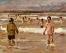 As crianças tomando banho no mar