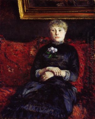 Femme assise sur un canapé fleuri rouge