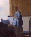 kvinna läser ett brev kvinna i blått som läser ett brev